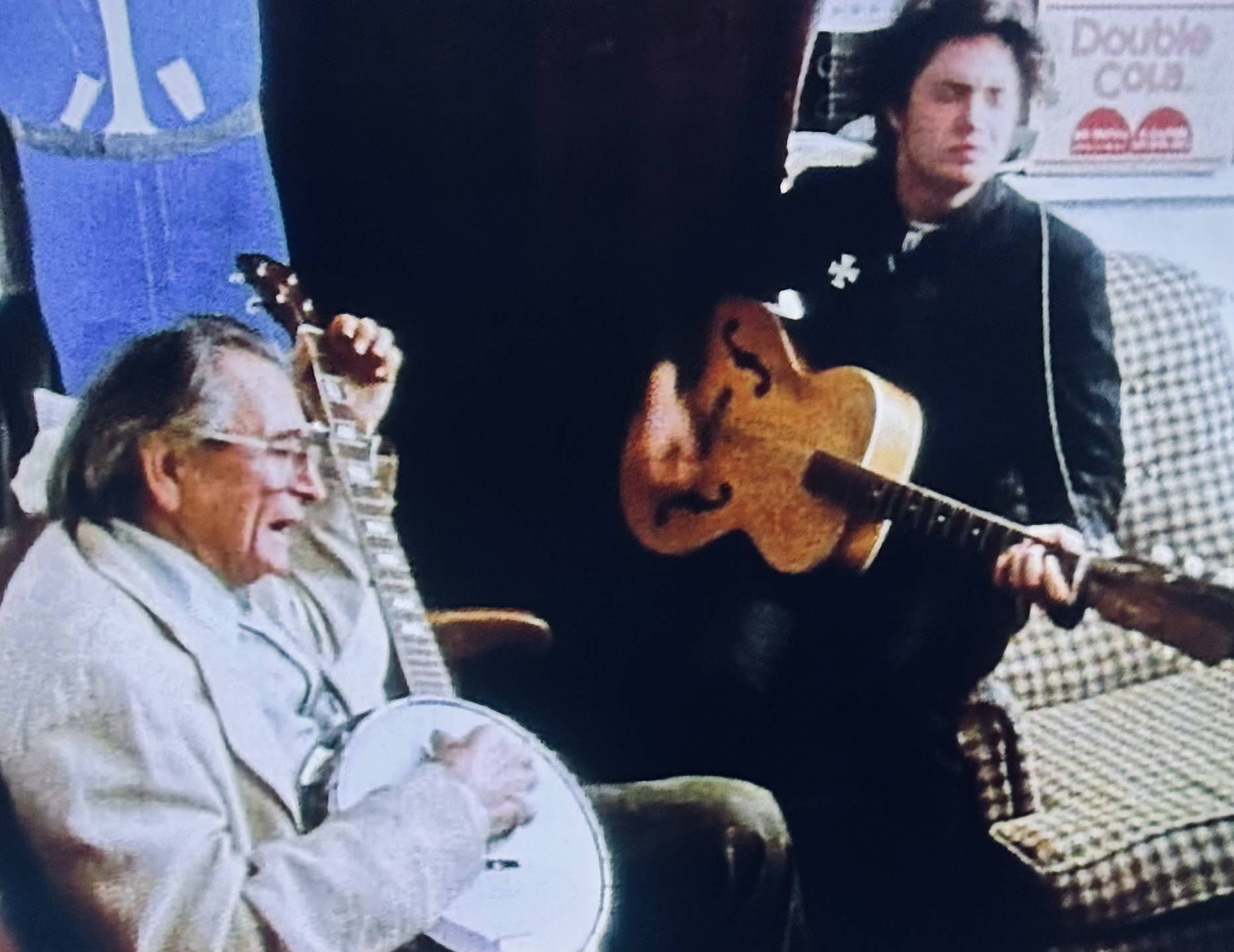 older man playing the banjo with younger man playing guitar