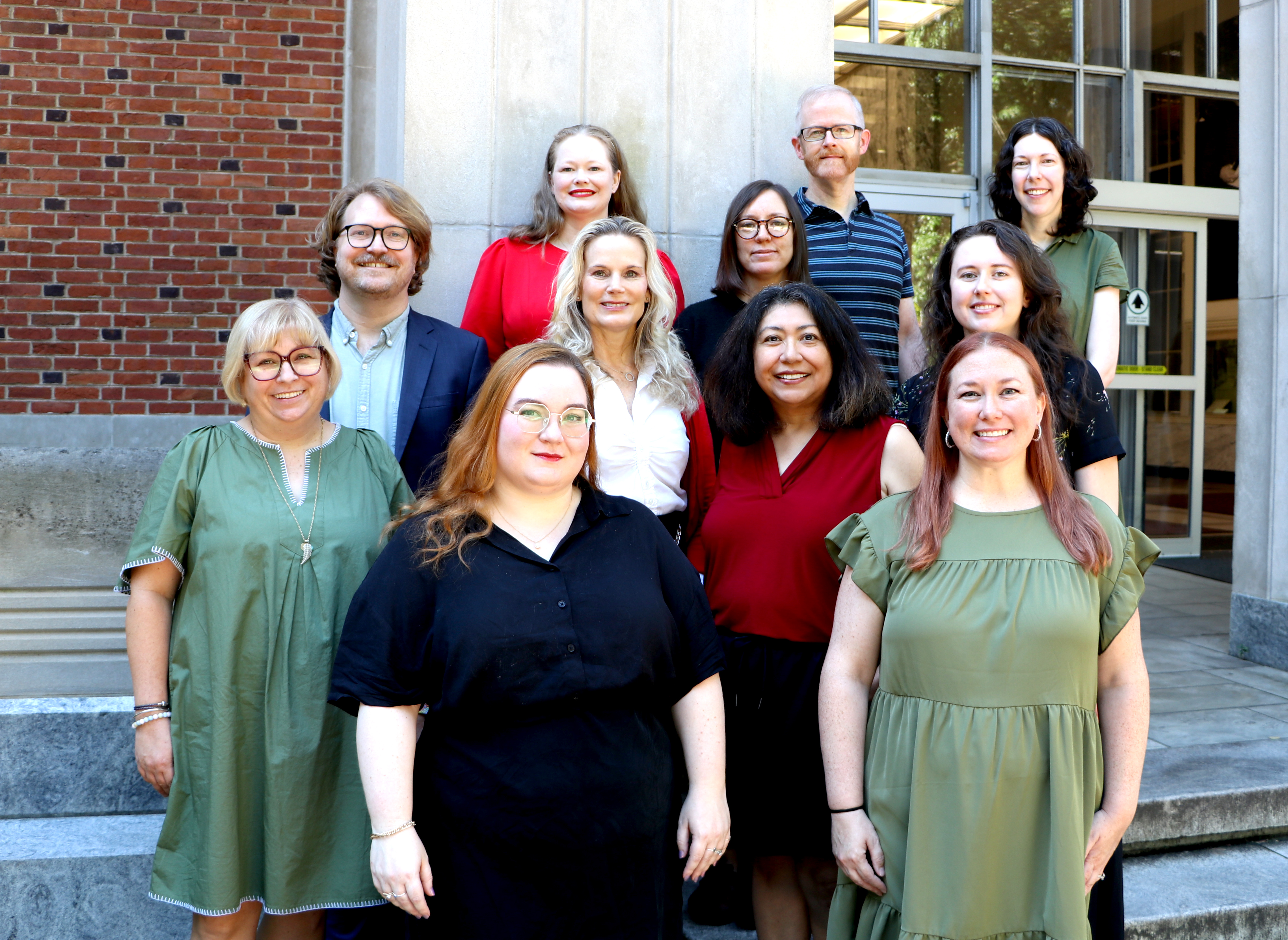 A group of friendly librarians standing on the steps of the Main Library