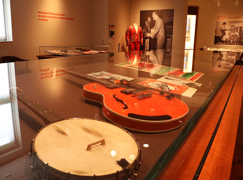 A banjo, electric guitar and concert fliers on display