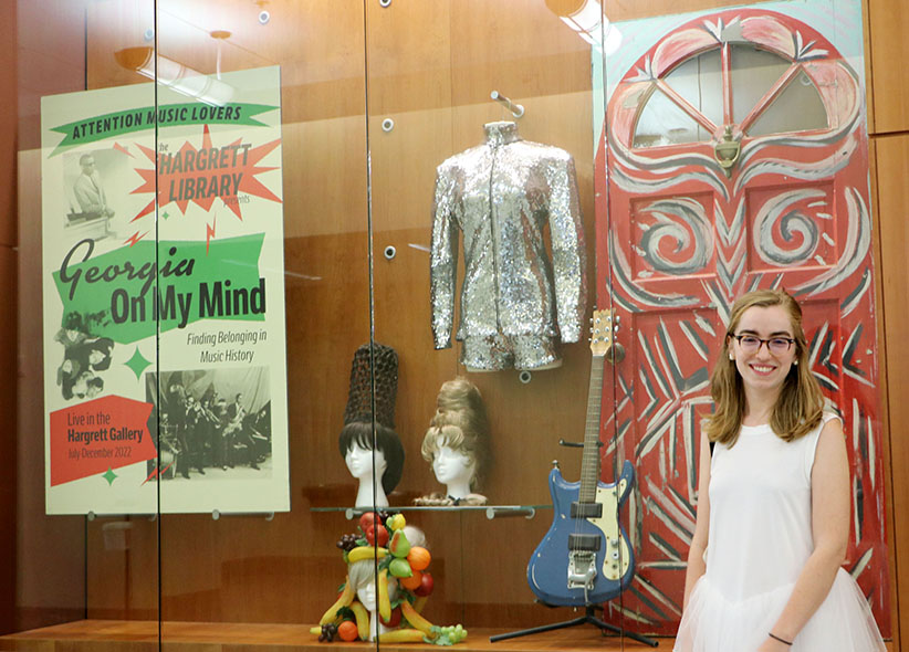 Maggie Neel poses by an exhibit case