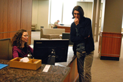 Reference desk staff member helping patron