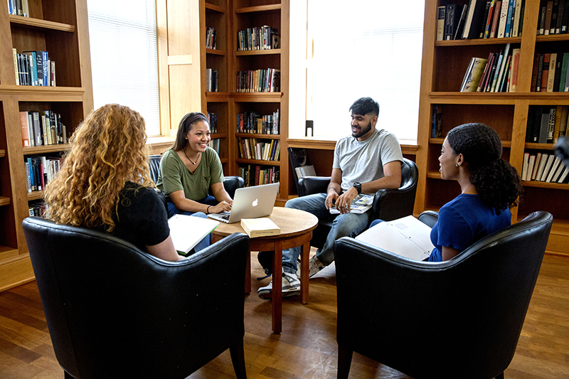 group of graduate students talking in the MLC Reading Room