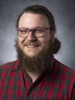 Bearded man with ponytail wearing glasses