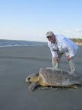 Photo of Brian Meyer on a beach with a sea turtle