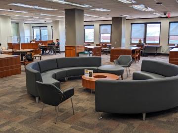 A large open area with a mix of desks, armchairs and semi-circular couches